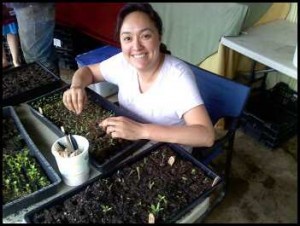 The author transplanting seedlings into bigger soil blocks